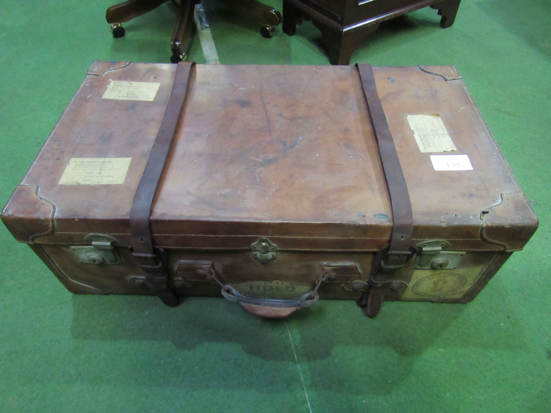 Large leather suitcase complete with straps, 80 x 26 x 40cms. Estimate £20-40.
