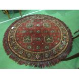 Round deep pile fireside rug in deep red with lozenge design. Diameter 137cms. Estimate £20-30.