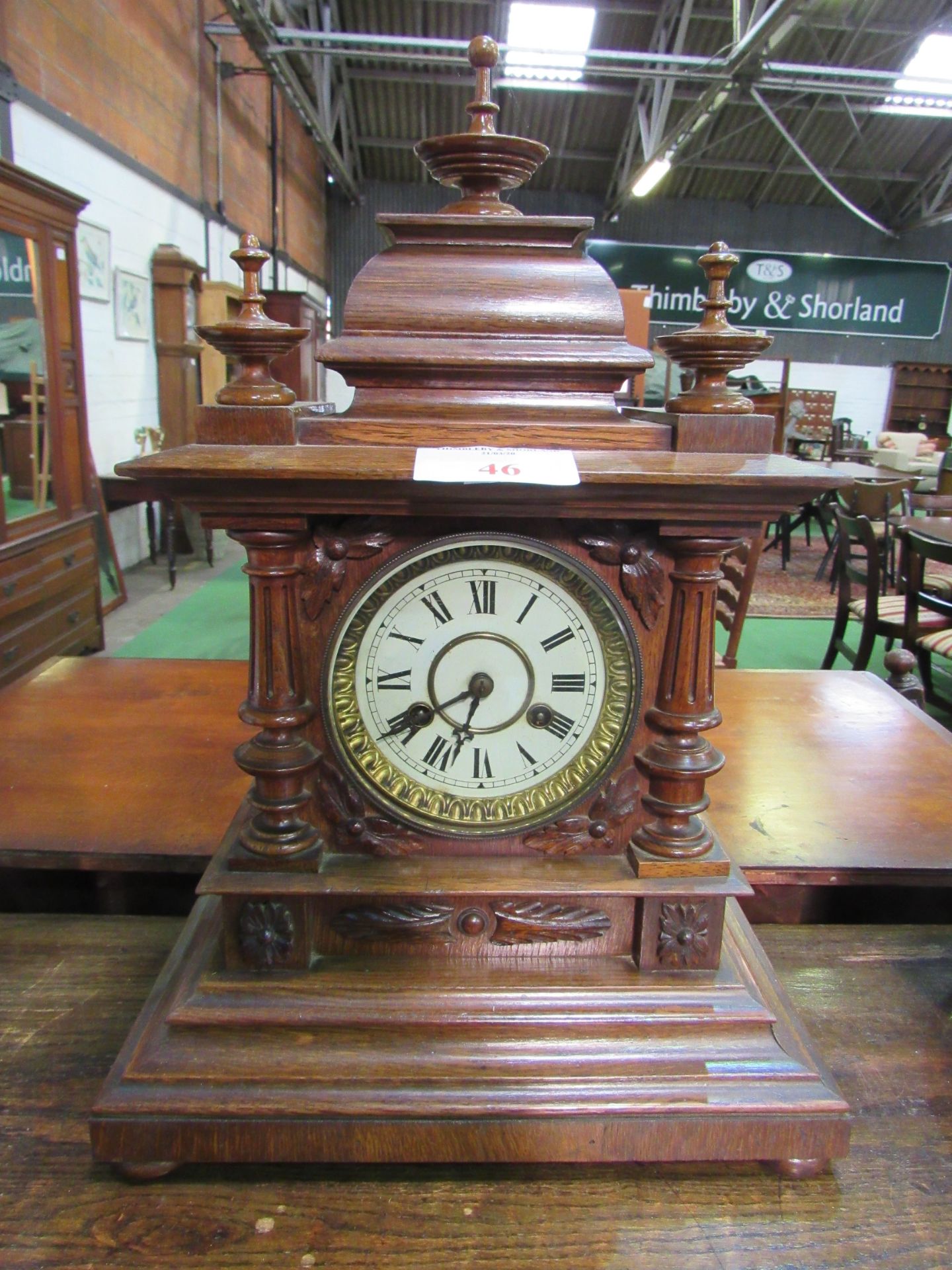 Oak case mantel clock with finial decoration. Height 52cms. Estimate £40-60.