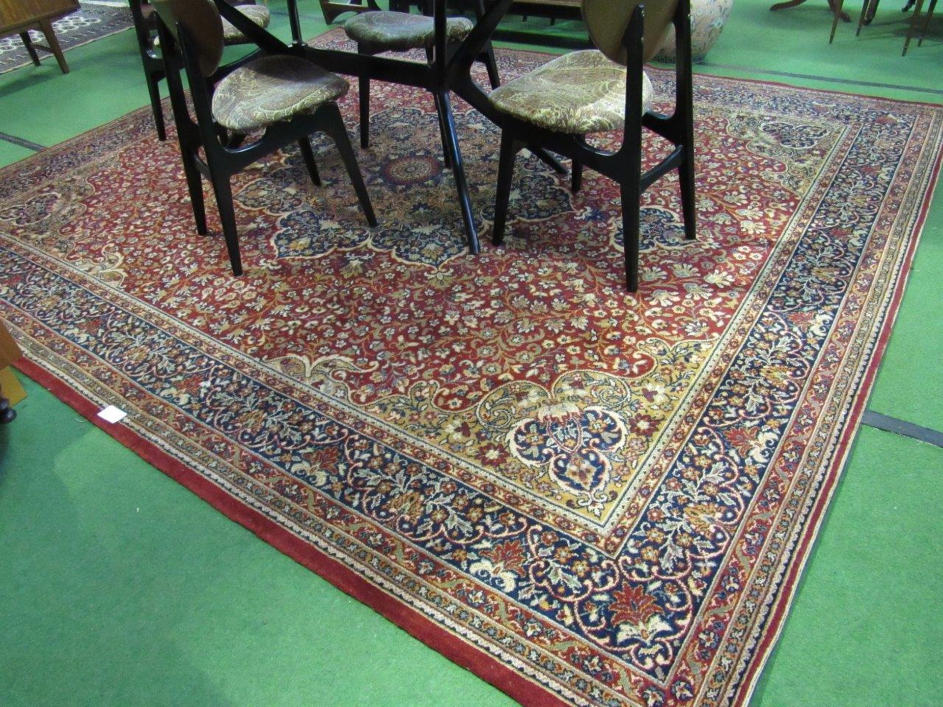 Red ground carpet 325 x 276cms. Estimate £50-80.