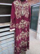 Burgundy velvet robe with gold embroidery and lace cuffs.