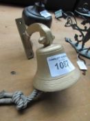 Ship bell style door bell with original clapper and lanyard, on wall bracket.