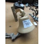 Ship bell style door bell with original clapper and lanyard, on wall bracket.