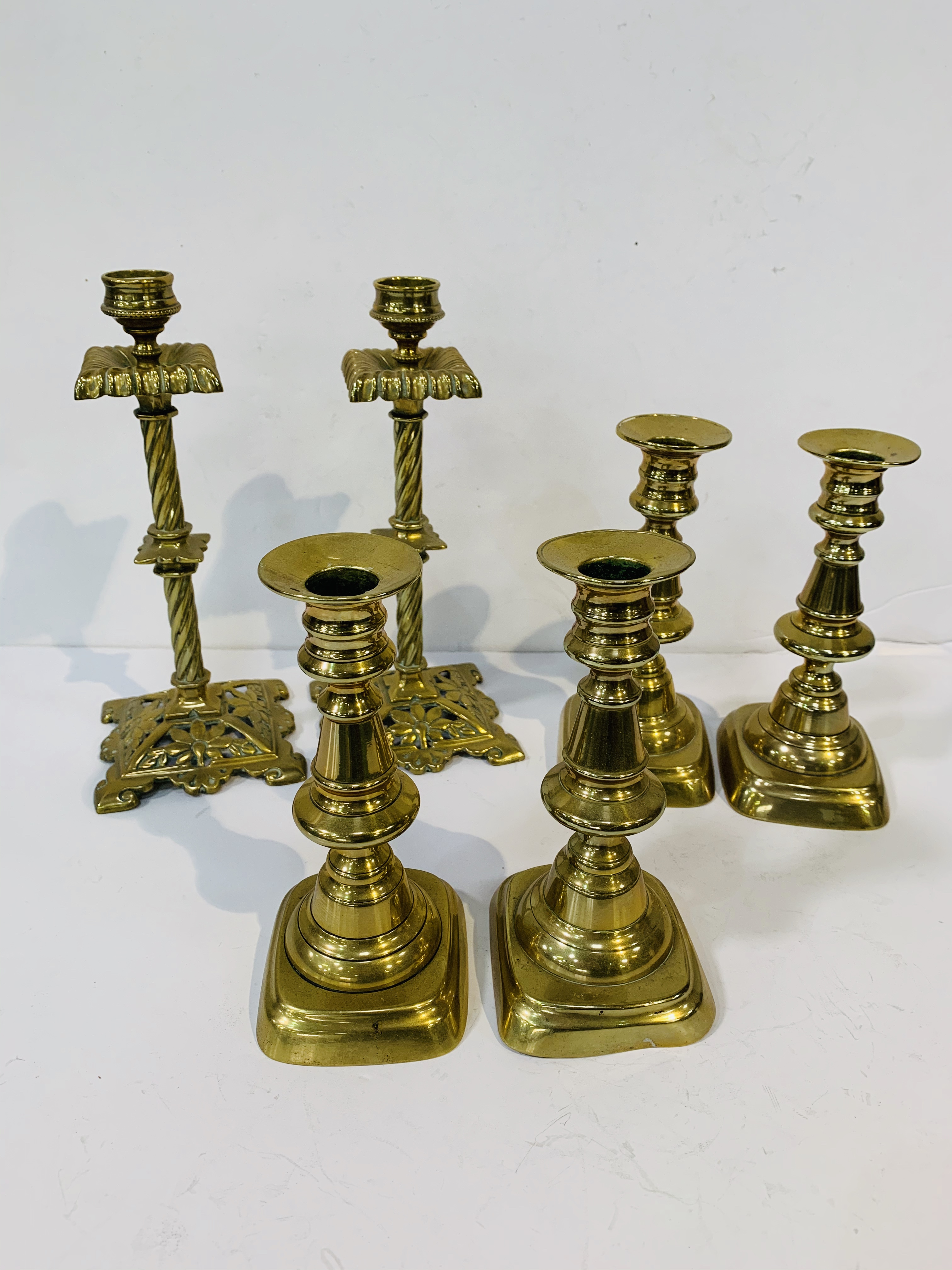 2 pairs of antique brass candlesticks, height 16.5cms; together with a pair of decorative antique br