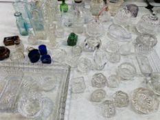 A large qty of glass objects including: candle holders; ashtrays; lidded pots; scent bottles; pair o
