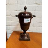 Brown lustre painted metal covered urn.