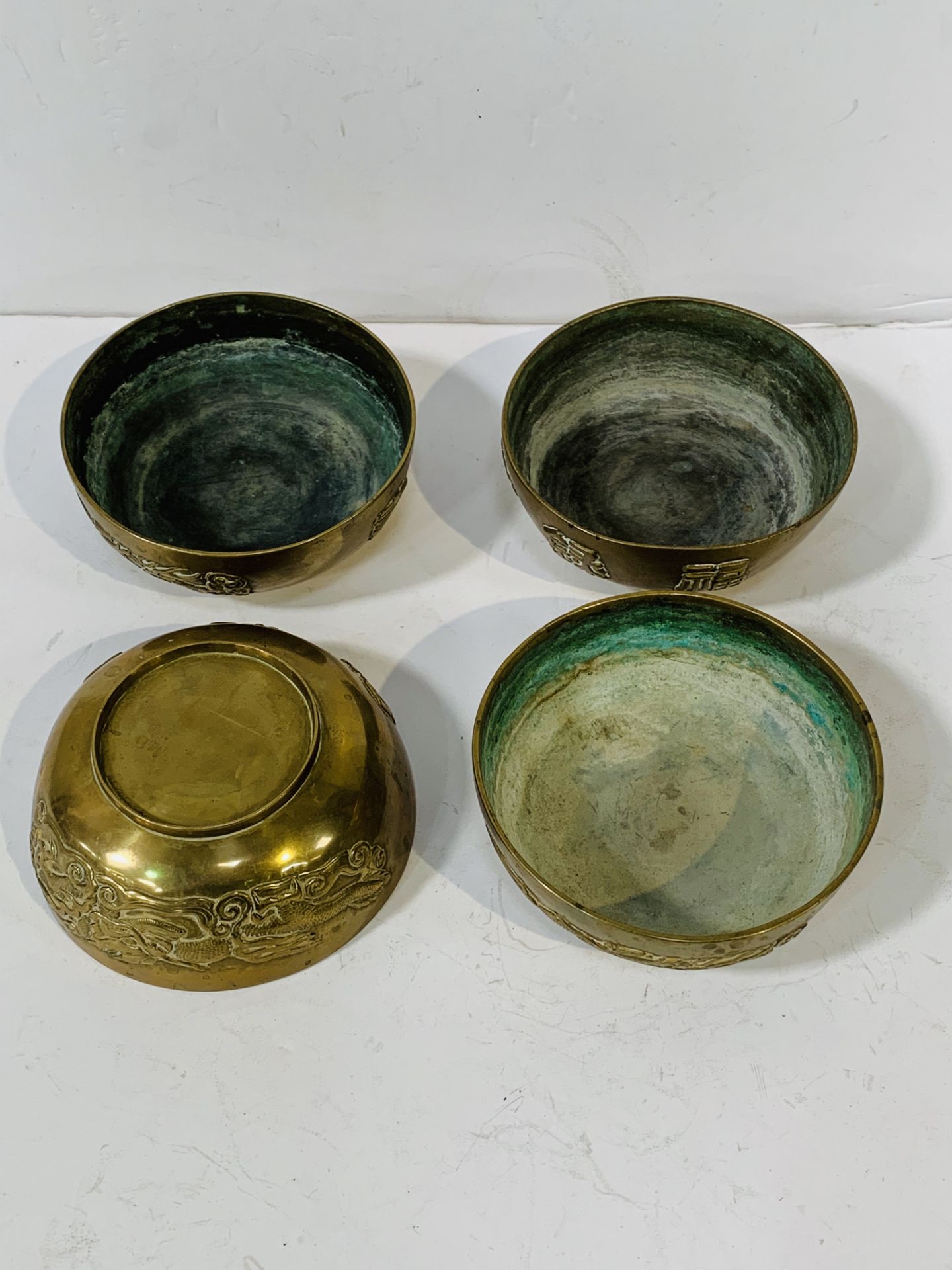 Set of 4 Chinese bronze 11.5cms bowls with Dragon design and character marks.