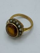 Victorian 9ct gold ring set with dark yellow stone surrounded by seed pearls