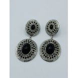 Pair of white metal earrings set with black stones