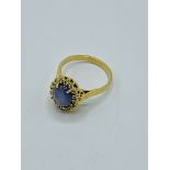 750 gold ring set with pale blue marbled stone surrounded with diamond chips