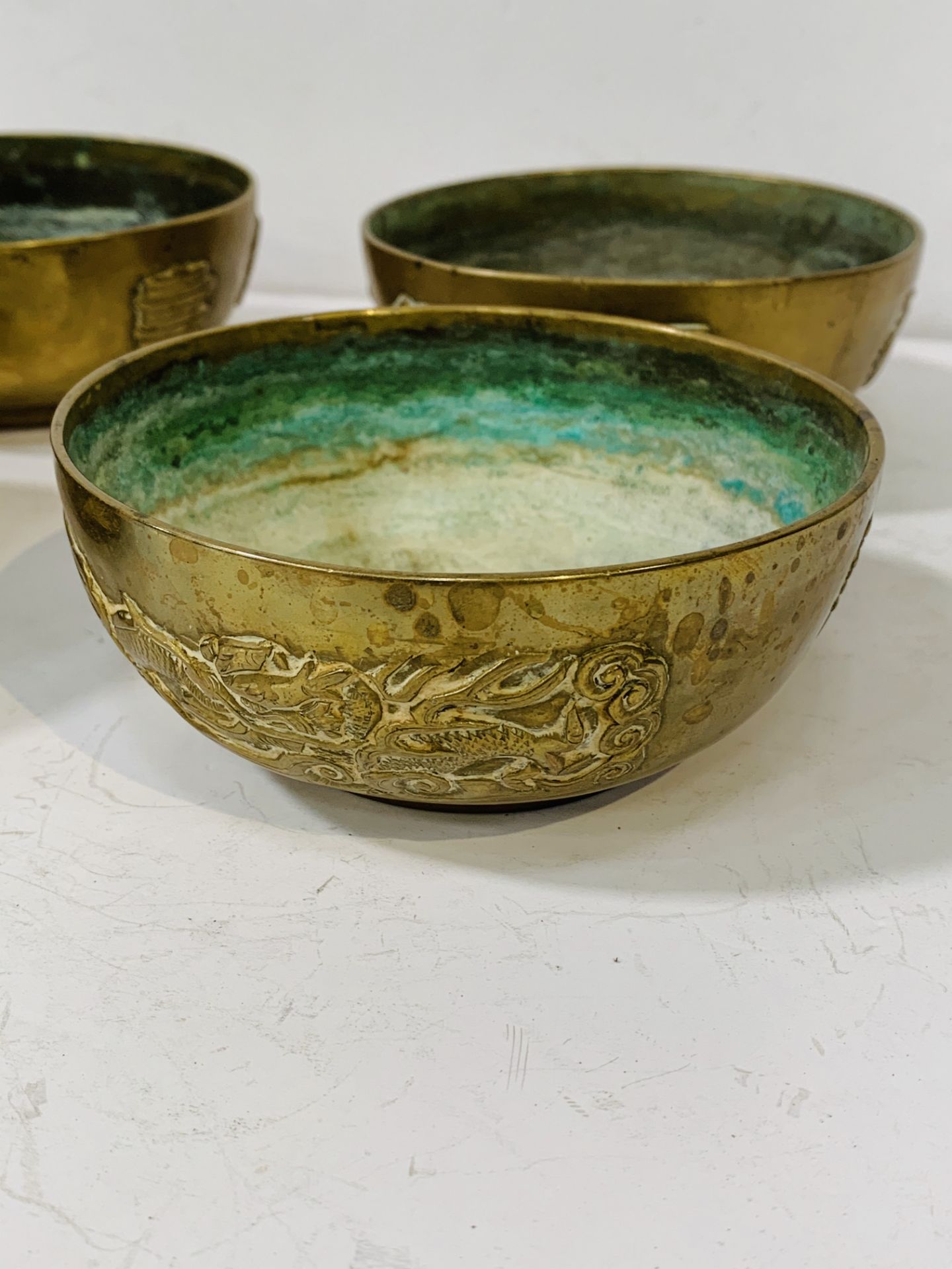 Set of 4 Chinese bronze 11.5cms bowls with Dragon design and character marks. - Image 2 of 3