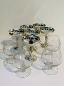 A set of 6 white metal champagne coupes together with 4 large cut glass brandy balloons.