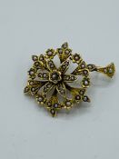 Antique yellow metal floral pendant set with seed pearls.