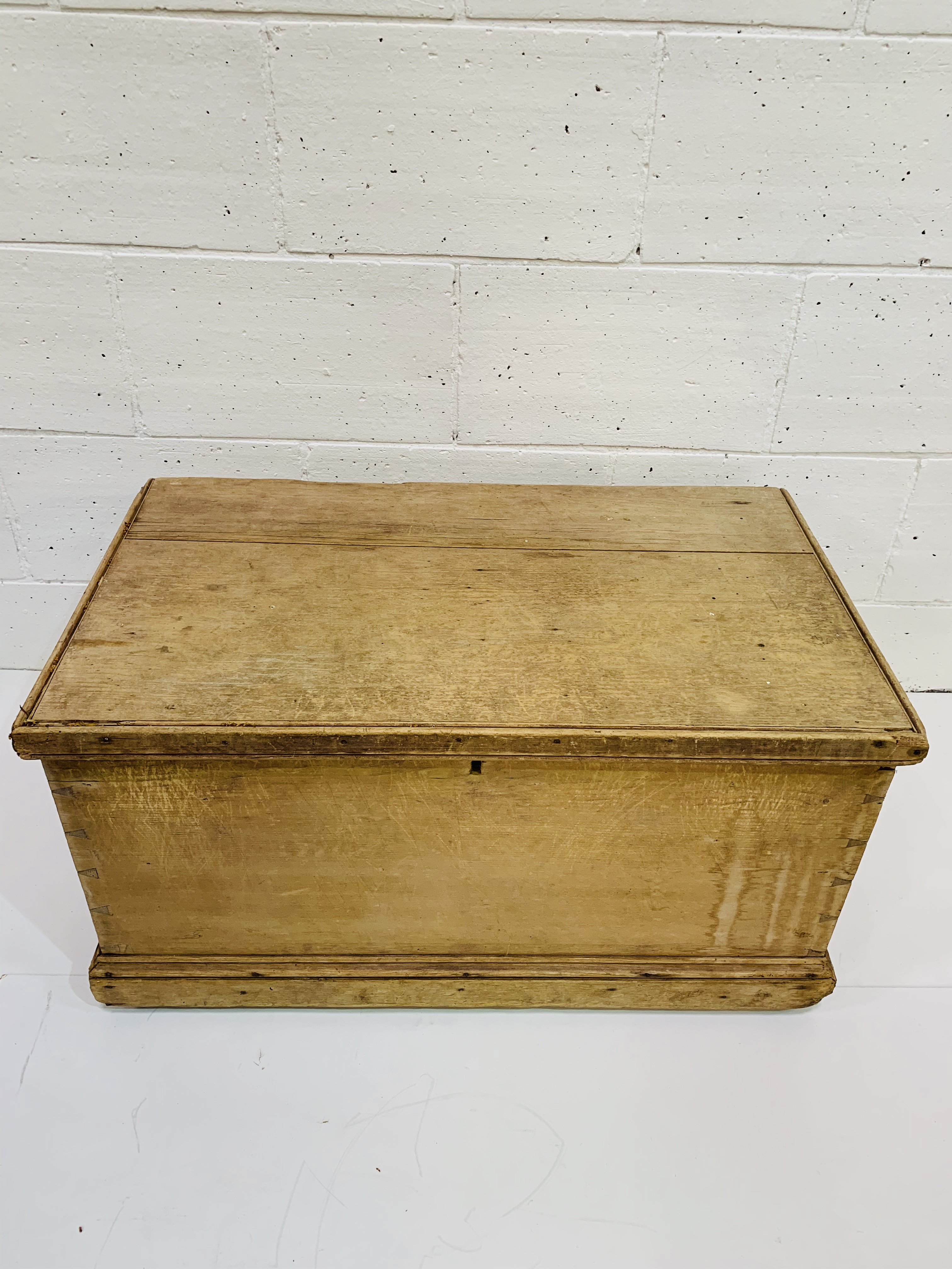 A pine chest with metal carry handles.