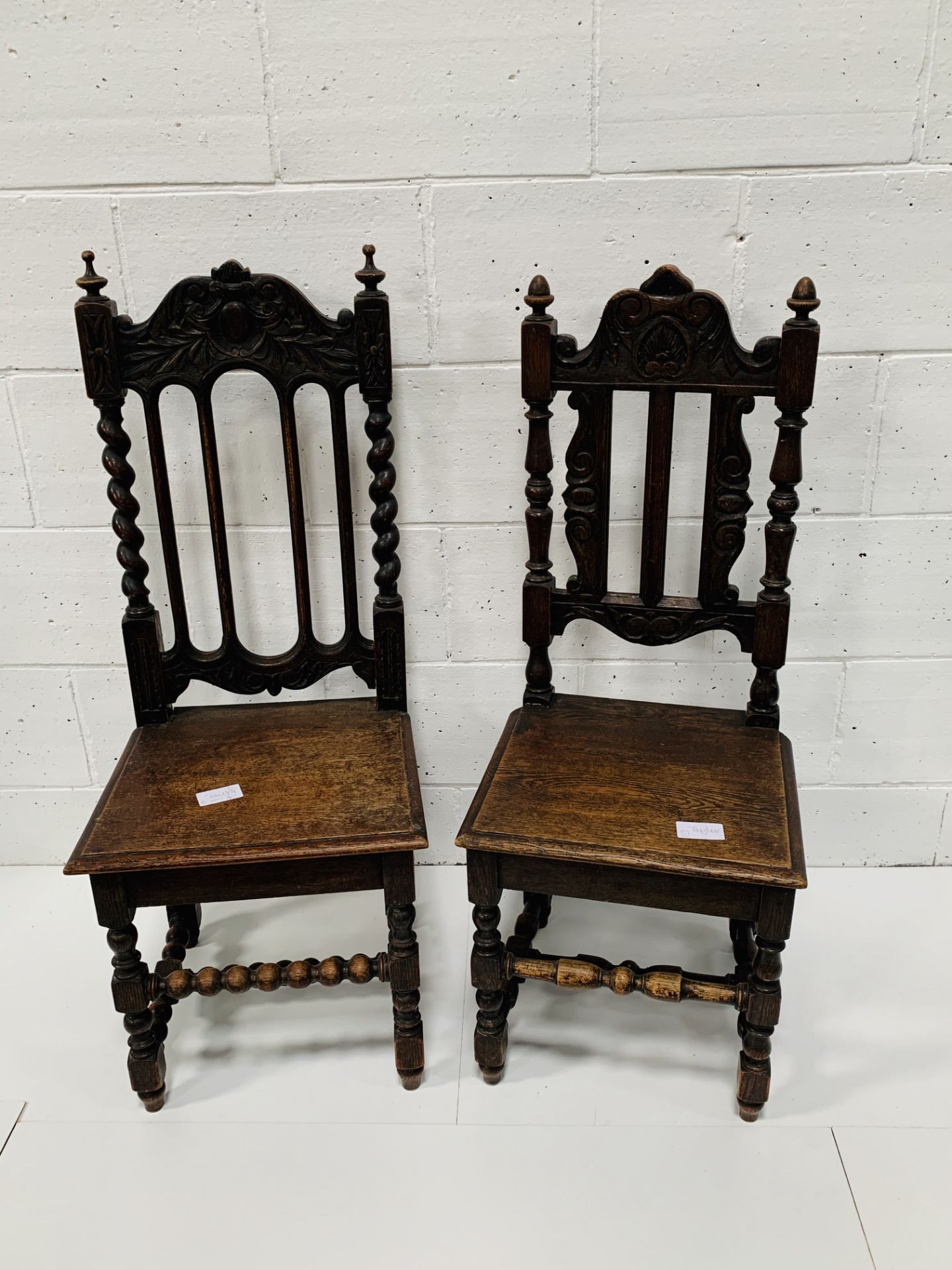 Two antique oak hall chairs and an oaked framed screen.