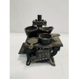 "Queen" miniature cast iron stove, complete with miniature saucepans.