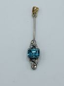 White metal pendant set with a pale blue stone and diamonds.