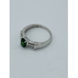 9ct white gold ring set with a green stone and diamonds to shoulders.