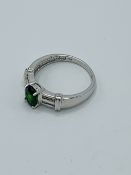 9ct white gold ring set with a green stone and diamonds to shoulders.