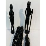 3 carved ethnic figures; a tall ethnic carving of people with sacks; wooden pestle & mortar;