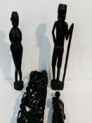 3 carved ethnic figures; a tall ethnic carving of people with sacks; wooden pestle & mortar;