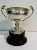 Large Art Nouveau twin handled sterling silver trophy on bakelite plinth.