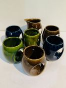 Set of 6 Holkham pottery owl mugs T106: 2 green, 2 blue, 2 brown; and a brown creamer