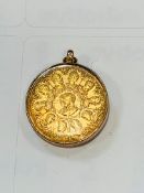 Gold coloured medalet of Queen Victoria.