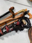 Seven various walking sticks and a pair of carved wooden bellows.