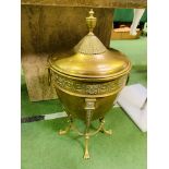 A large brass covered urn on a four legged stand.