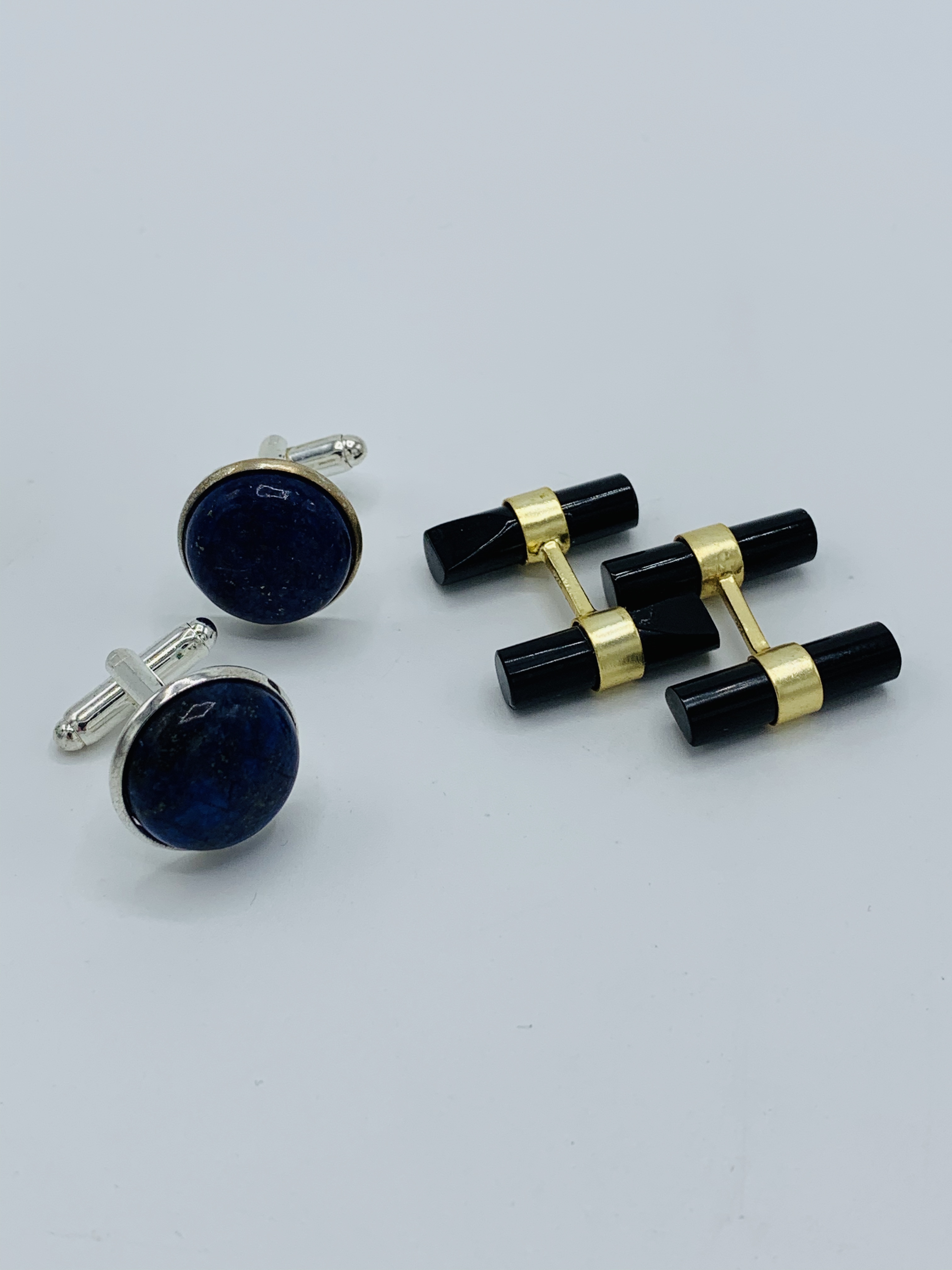 Pair of black onyx cufflinks and a pair of lapis lazuli cufflinks.