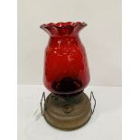 A paraffin lamp with ruby glass shade.