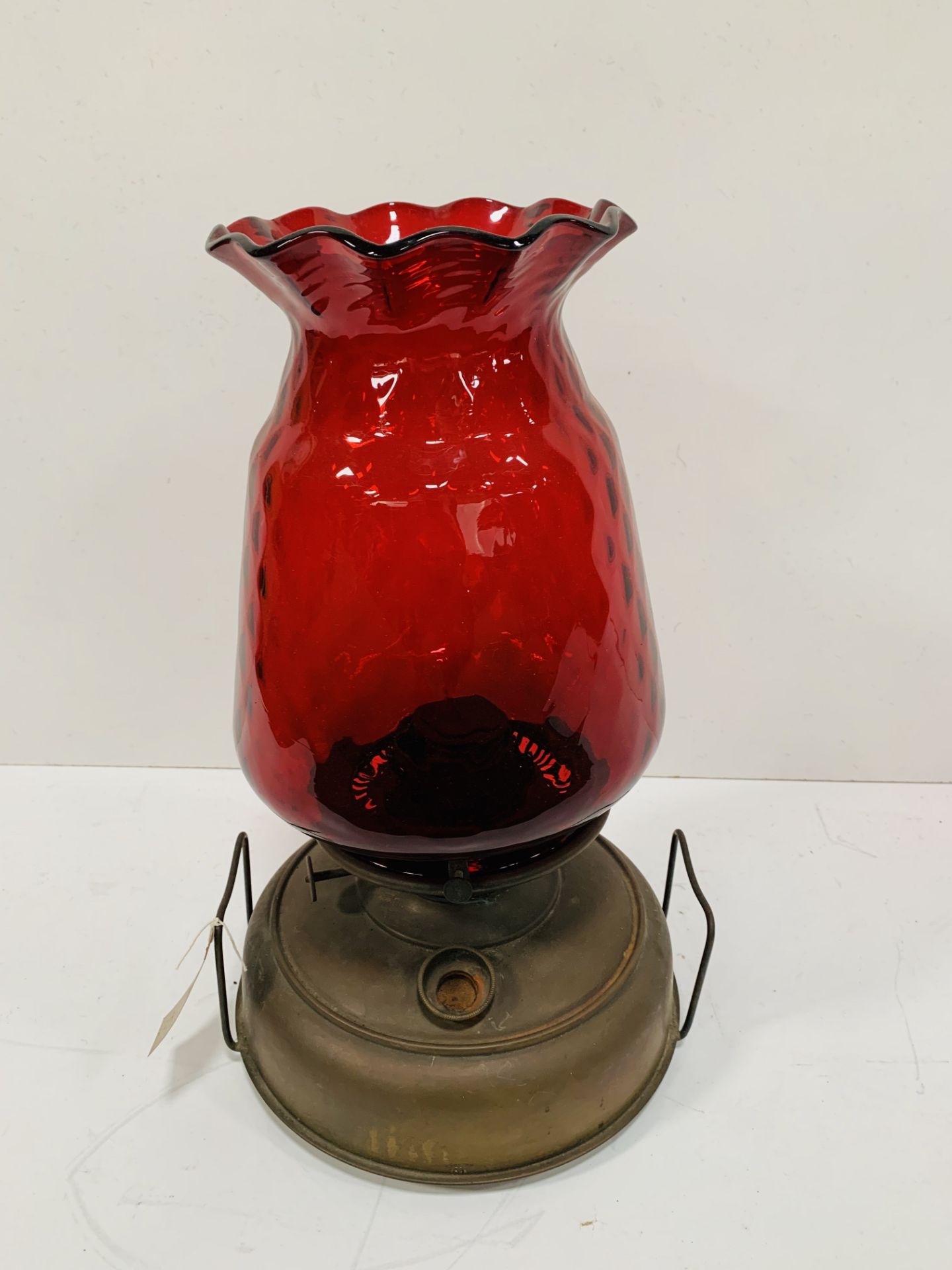 A paraffin lamp with ruby glass shade.