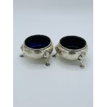 2 silver salt pots with blue glass liners.