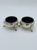 2 silver salt pots with blue glass liners.