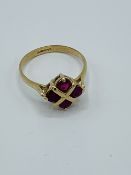 9ct gold ring set with 4 red stones in a square.