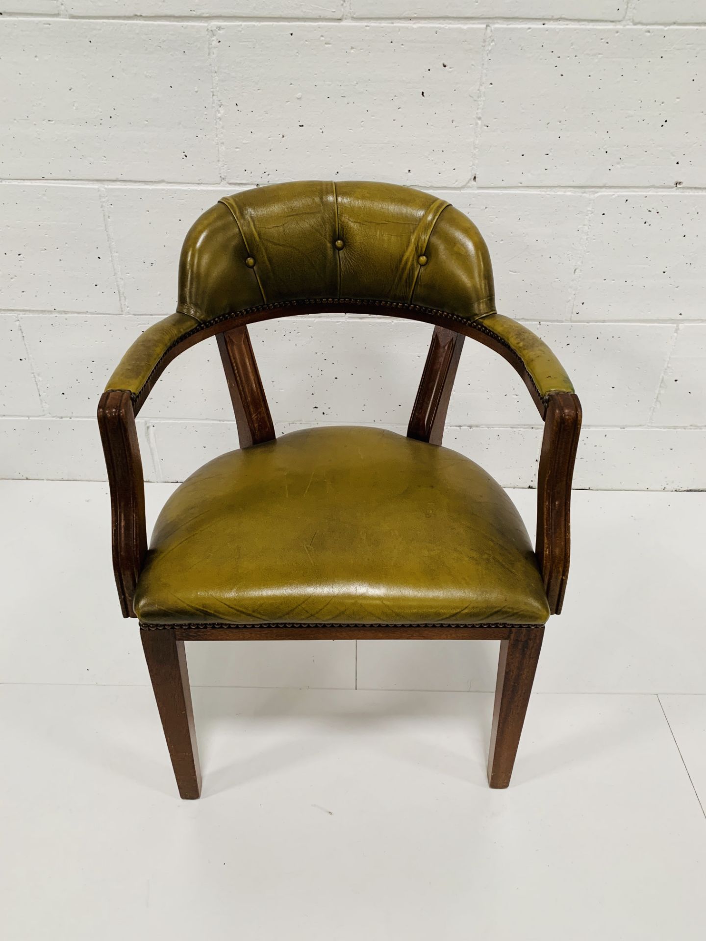 Green leather open armchair.