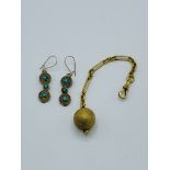 Yellow metal ball on fob, and a pair of turquoise earrings.