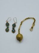 Yellow metal ball on fob, and a pair of turquoise earrings.