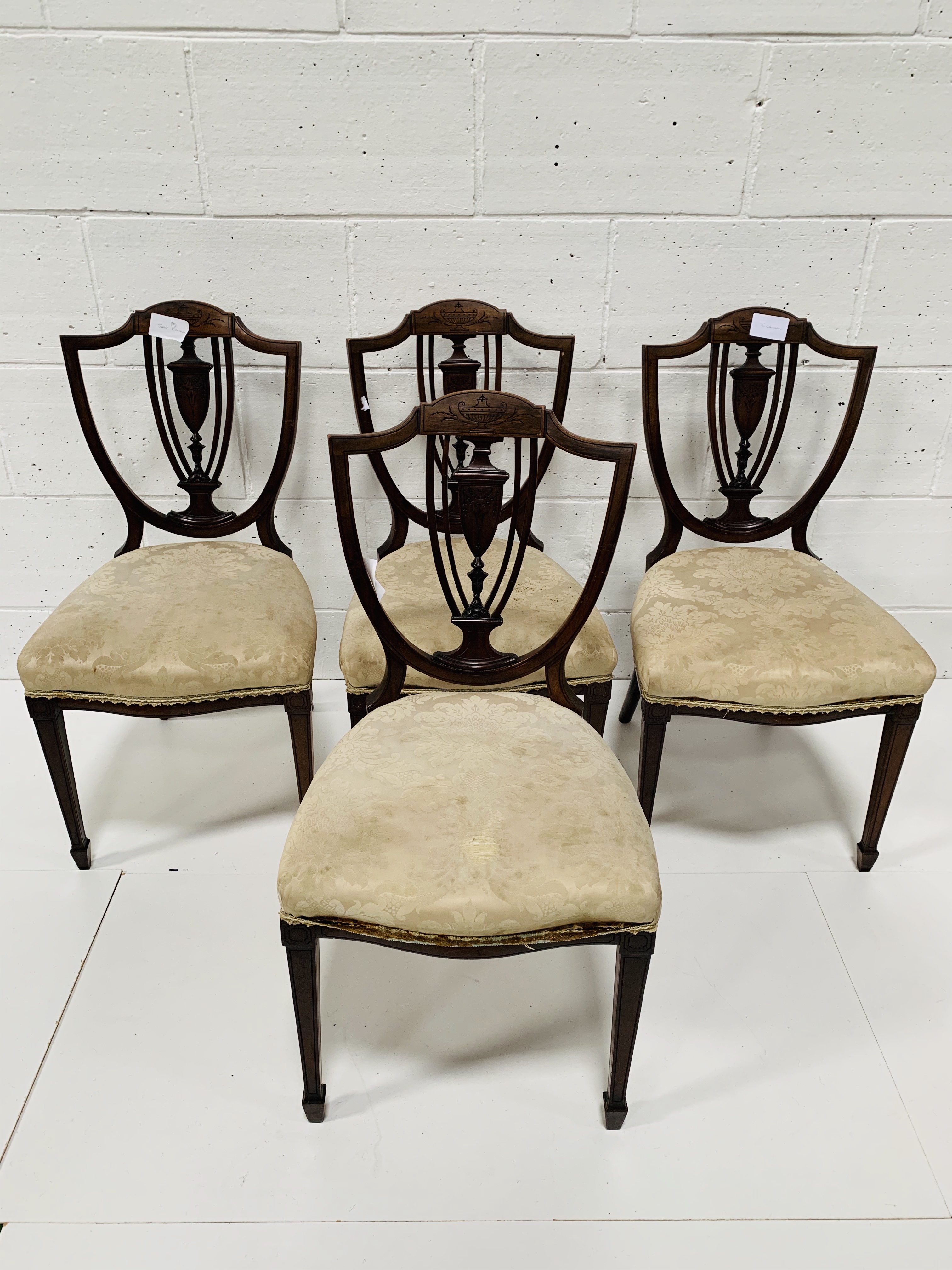Four mahogany shield back dining chairs.