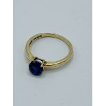 14ct gold ring set with a dark blue stone.