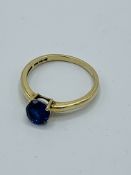 14ct gold ring set with a dark blue stone.