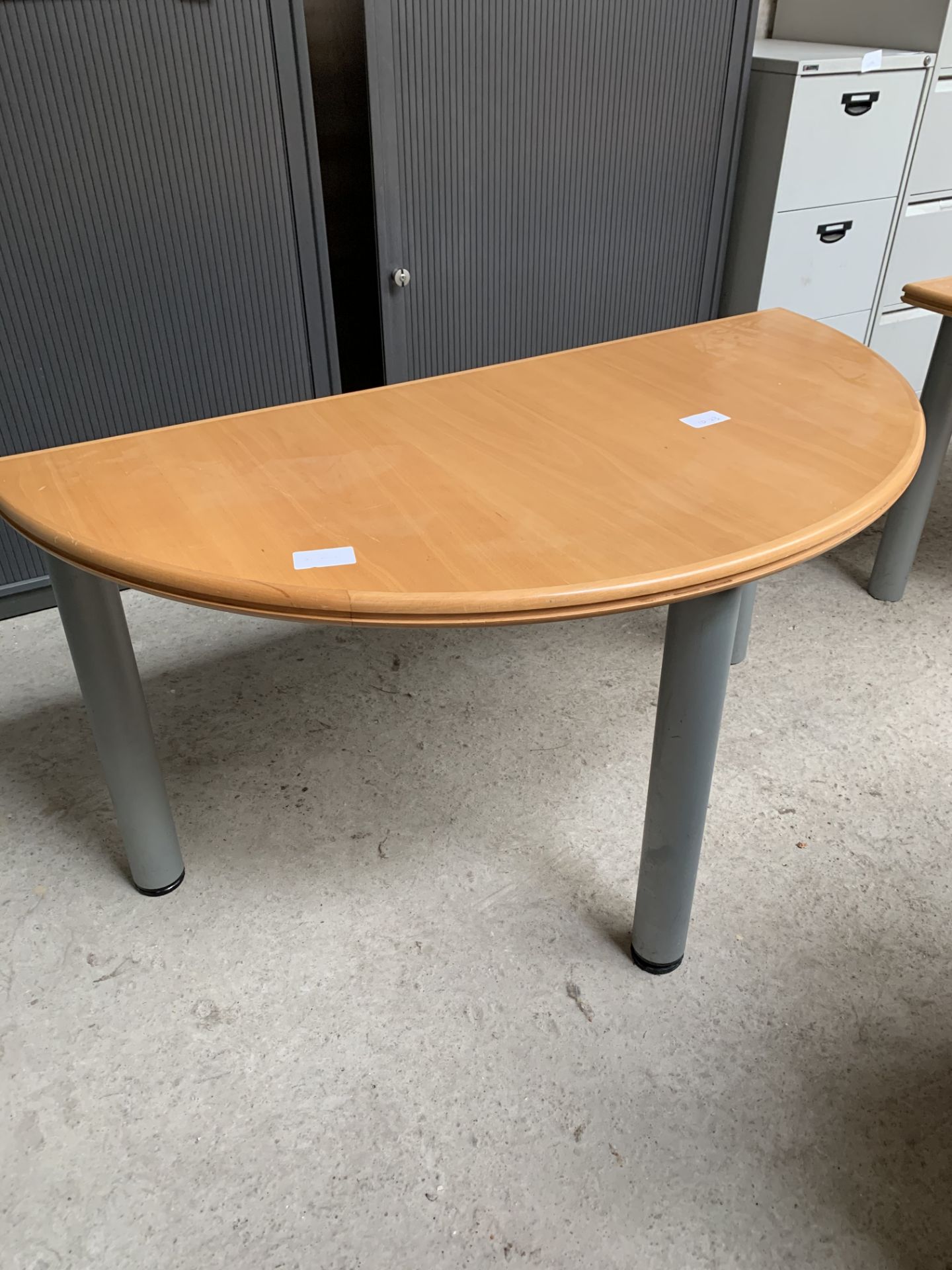 Laminate demi-lune table on metal supports. 140 x 70 x 71cms.