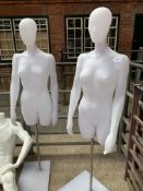 Two female mannequins on stands; a male seating mannequin; and a spare stand.