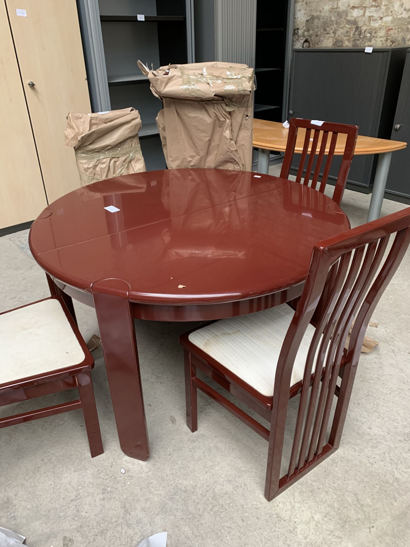 Circular extendable table with two leaves together with four matching chairs.