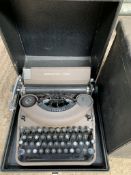 A Remington Rand portable typewriter in a box; together with two cases of 78RPM records.