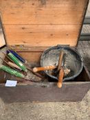 A pine box containing various garden hand tools.