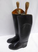 Pair of long black leather riding boots with wooden trees, size 10.