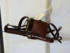 Brown leather driving bridle with brass fittings by Stelinski