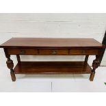 Mahogany sideboard with three frieze drawers over display shelf.
